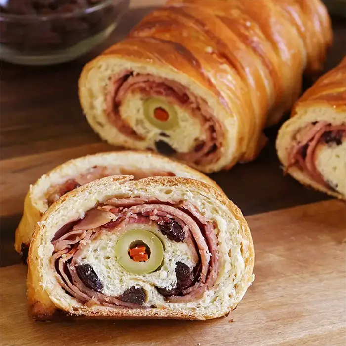 Pan de jamón venezolano recién horneado, dorado y relleno con jamón, pasas y aceitunas